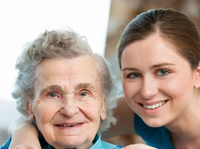 Compassionate caregiver sharing a smile with a senior client in their living room