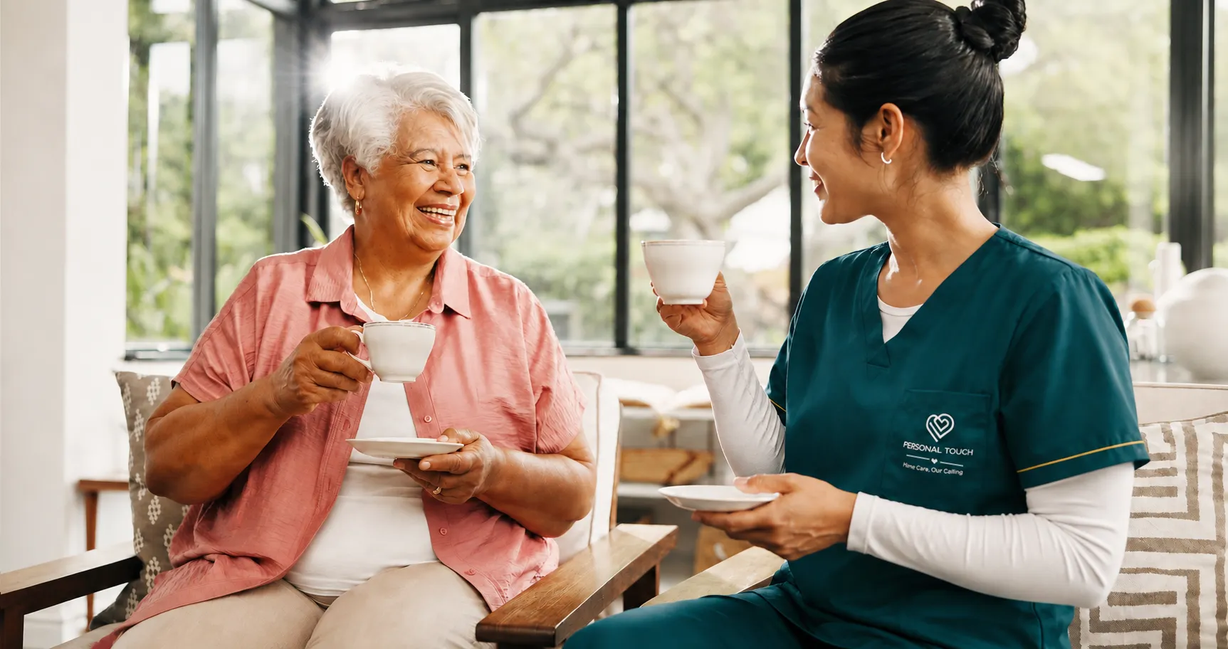 Caregiver and client sharing tea in a bright living room